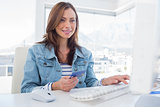 Cheerful woman purchasing online with her credit card