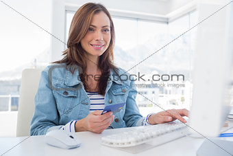 Cheerful woman purchasing online with her credit card