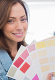 Attractive interior designer holding up colour samples