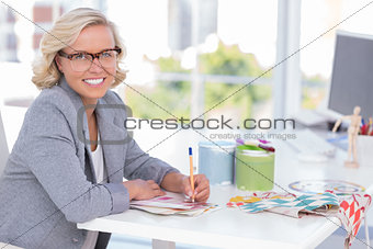 Cheerful interior designer working on colour charts