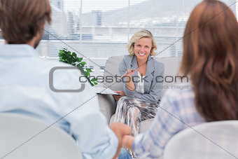 Smiling psychologist talking to a couple