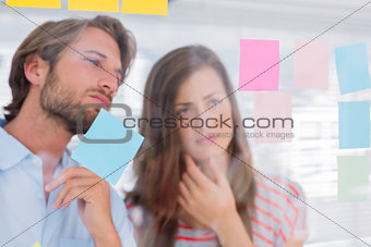 Two colleagues looking at sticky notes