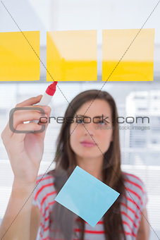 Young woman writing on sticky note