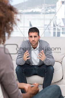 Upset man speaking to a therapist
