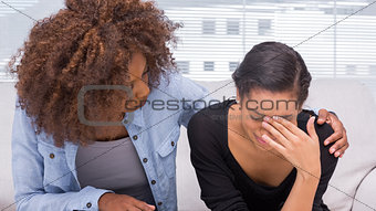 Sad woman crying next to her therapist