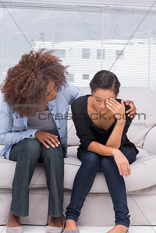 Woman crying next to her therapist