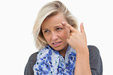 Worried blonde pointing to forehead