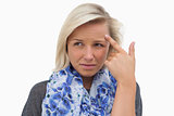 Anxious blonde pointing to forehead
