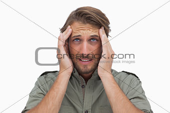 Man grimacing with pain of headache and looking up