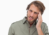 Man with headache looking away and wincing