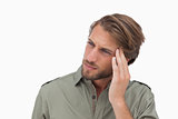 Man with headache looking away and touching his head