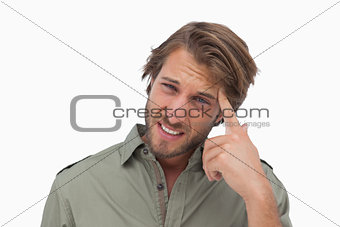 Man with headache touching his head and looking at camera