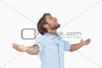 Happy man looking up with arms outstretched