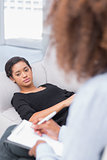 Woman lying on therapists couch looking unhappy