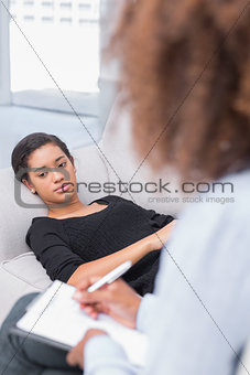 Woman lying on therapists couch looking unhappy