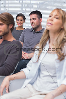 Patients listening in group therapy with one girl smiling