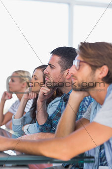 Creative team sitting in a line listening to something