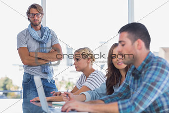 Man standing with arms folded in creative office