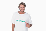 Smiling man pointing to his volunteer tshirt