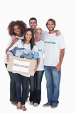 Happy group of volunteers holding donation box