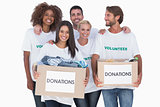 Happy group of volunteers holding clothes donation boxes