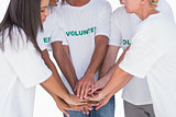 Happy volunteers putting hands together