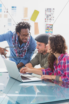 Creative team working together on laptop