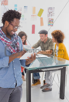 Designer standing and using his tablet