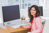 Woman working in a creative office and smiling at camera