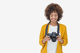 Woman looking at her digital camera and smiling