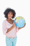 Woman holding and pointing to globe