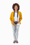 Smiling girl holding digital camera and looking at camera