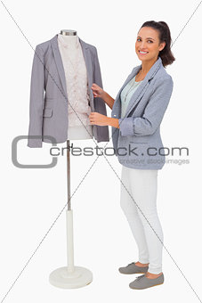 Fashion designer fixing blazer on mannequin