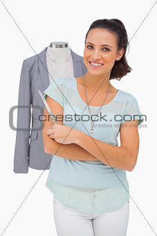 Designer holding scissors in front of mannequin