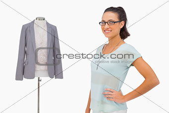 Designer smiling beside her mannequin