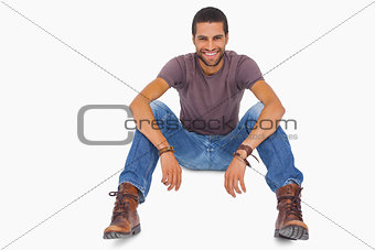 Handsome man sitting on floor and smiling