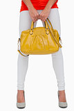 Woman in white leggings holding yellow bag