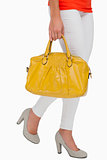 Woman in high heels walking with yellow bag