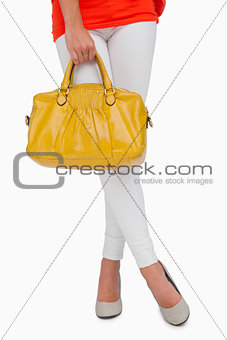 Woman in high heels standing with yellow bag
