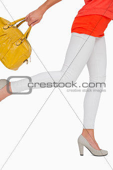 Woman in high heels rushing with yellow bag
