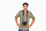 Serious man in peaked cap with camera around his neck