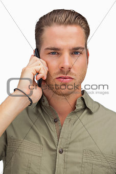 Serious man on the phone looking at camera