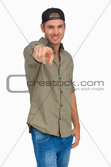 Man smiling and wearing baseball hat backwards and pointing