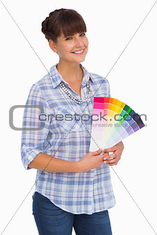 Pretty woman with fringe holding colour charts