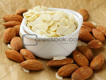 whole nuts and blanched almonds in white bowl