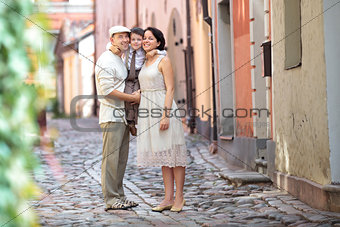 Happy young family in city street