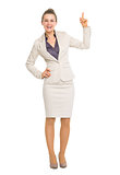 Happy business woman pointing up on copy space