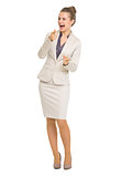 Full length portrait of happy business woman pointing in camera