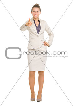 Full length portrait of smiling business woman showing thumbs up