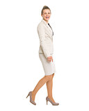 Full length portrait of happy business woman going sideways